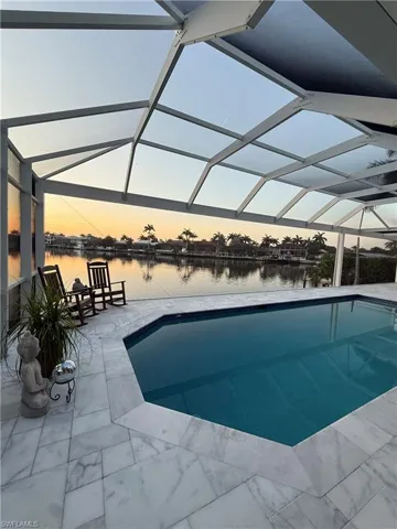 Outdoor pool featuring a water view, a lanai, and a patio area