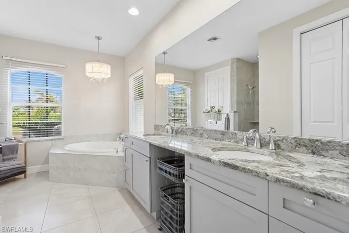 Bathroom featuring an inviting chandelier, tile patterned flooring, visible vents, and a sink