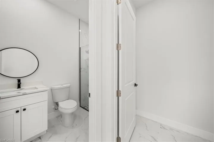 Outdoor pool bathroom with marble-finished vanity and shower