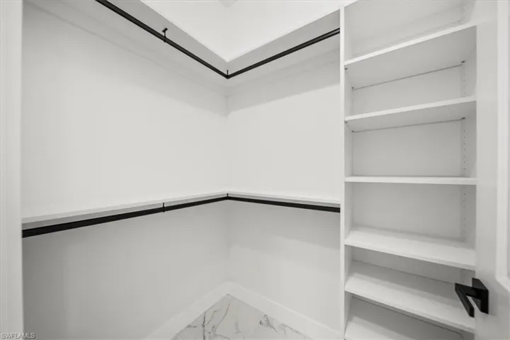 Spacious closet with light marble finish floors