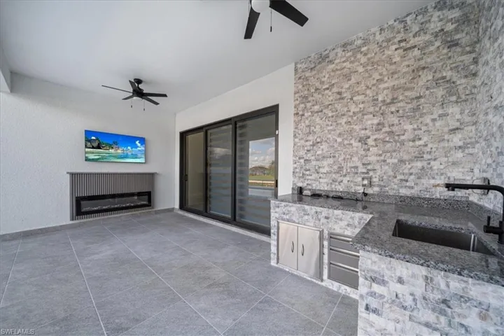 View of patio featuring area for grilling and ceiling fan