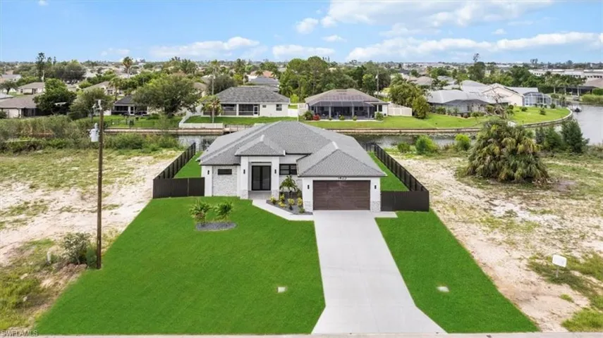 View of front of property with a residential view, driveway, and an attached garage