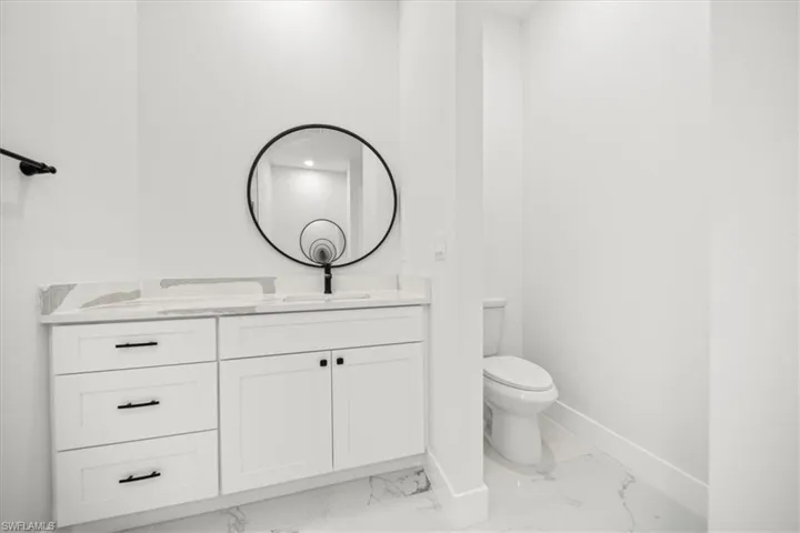 Bathroom with vanity and light marble finish flooring