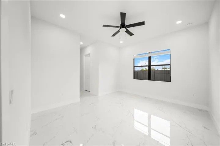 Empty room featuring recessed lighting, light marble finish floors, and ceiling fan