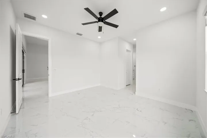 Unfurnished bedroom featuring recessed lighting, light marble finish flooring, and a ceiling fan