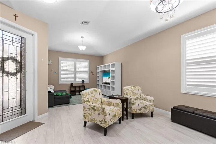Living area with laminate wood-type flooring and Plantation shutters.