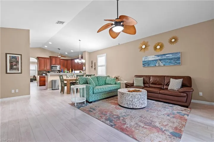 Great Room with vaulted ceiling, arched walkways, and laminate wood-style flooring