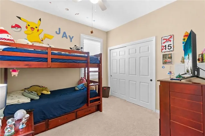 Carpeted 3rd bedroom featuring a bi-fold closet with white paneled doors, ceiling fan with light, and a window with blinds