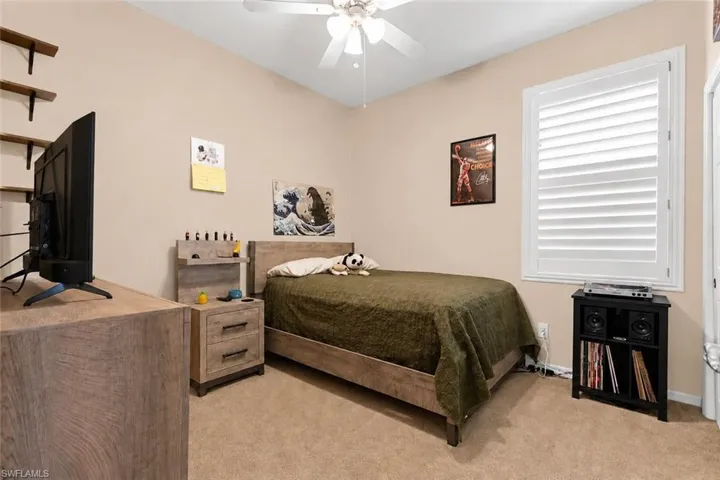 Second bedroom featuring plantation shutters, and neutral wall paint