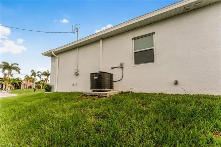 View of side of property featuring stucco siding and a lawn