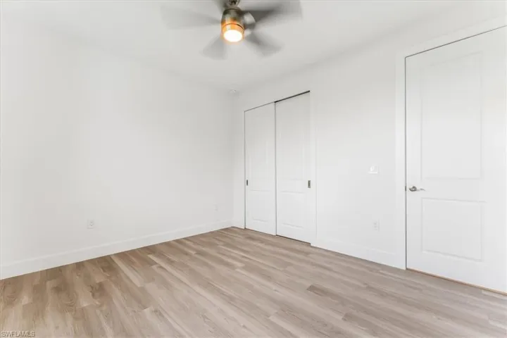 Unfurnished bedroom featuring light wood-style floors, a closet, and a ceiling fan