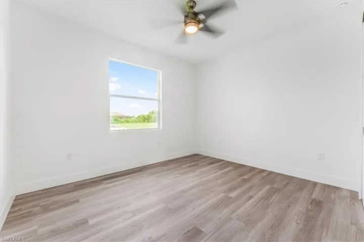 Empty room featuring a ceiling fan and light wood finished floors