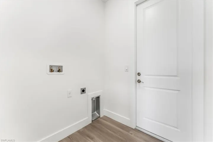 Washroom featuring hookup for an electric dryer, wood finished floors, and washer hookup