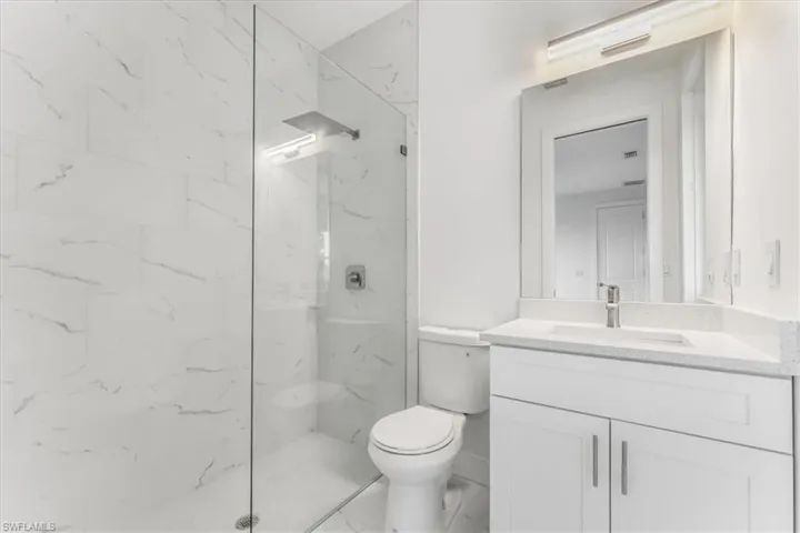 Full bathroom with vanity and a marble finish shower