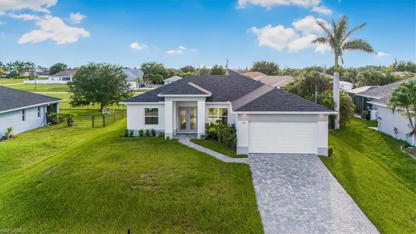 Ranch-style home featuring a garage, stucco siding, decorative driveway, french doors, and a residential view