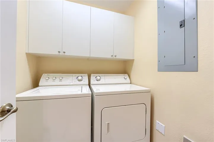 Washroom with electric panel, washing machine and clothes dryer, and cabinet space