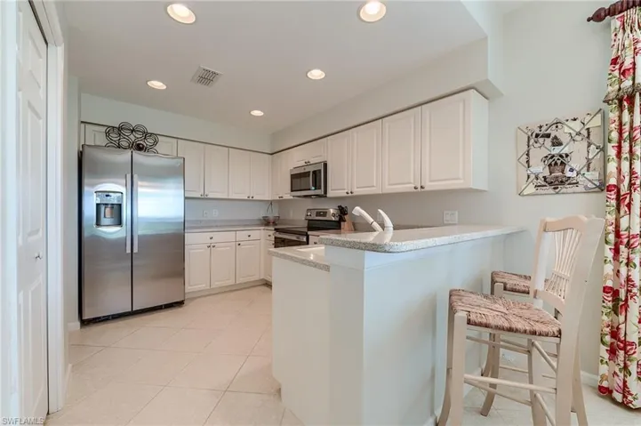 Kitchen featuring recessed lighting, white cabinets, a peninsula, and appliances with stainless steel finishes