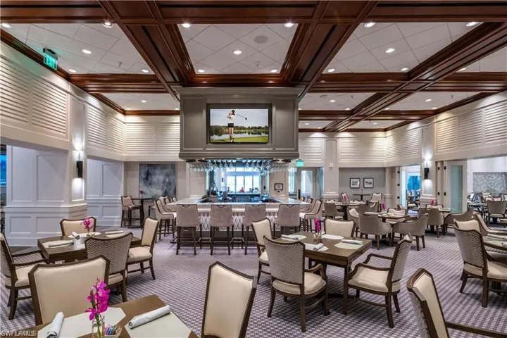 SWCC Carpeted dining area with a decorative wall, a towering ceiling, and coffered ceiling