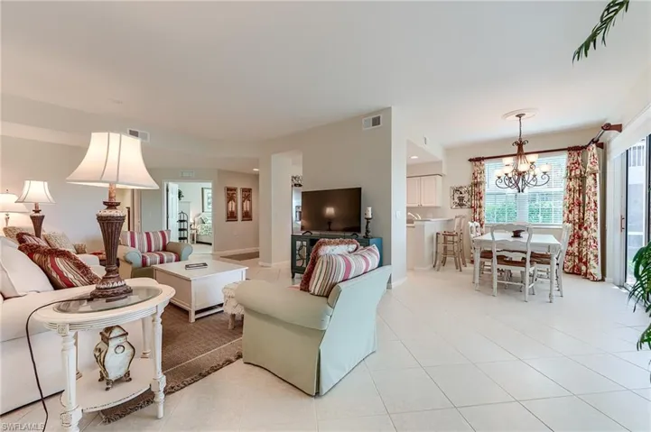 Living area with light tile patterned floors, and a chandelier