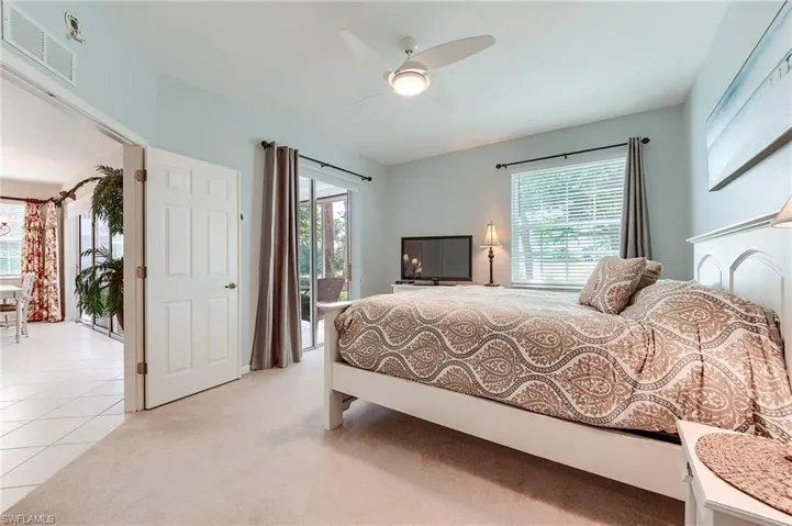 Bedroom featuring access to lanai, light colored carpet and ceiling fan