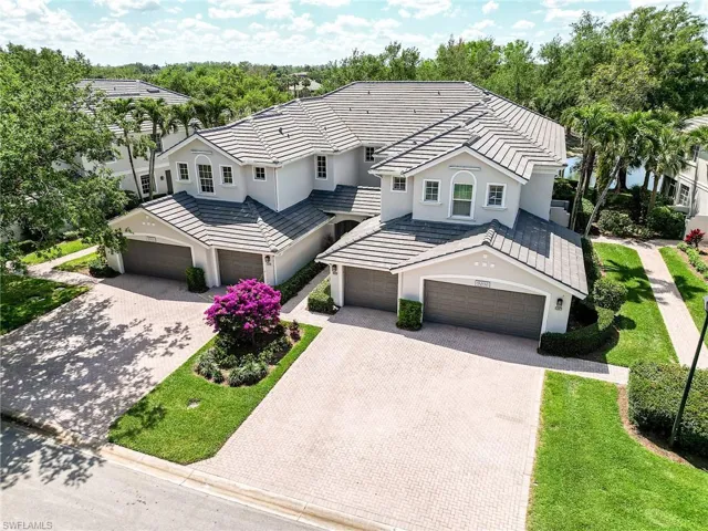 View of front facade with stucco siding, a garage, a tiled roof, and decorative driveway