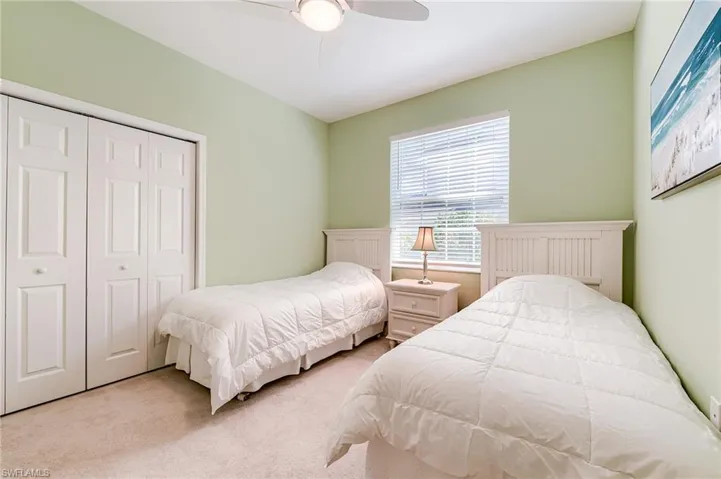 Bedroom with light carpet, a closet, and ceiling fan