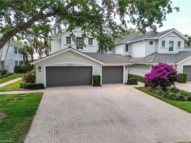 View of front of property featuring decorative driveway, a tiled roof, stucco siding, and an attached two car garage