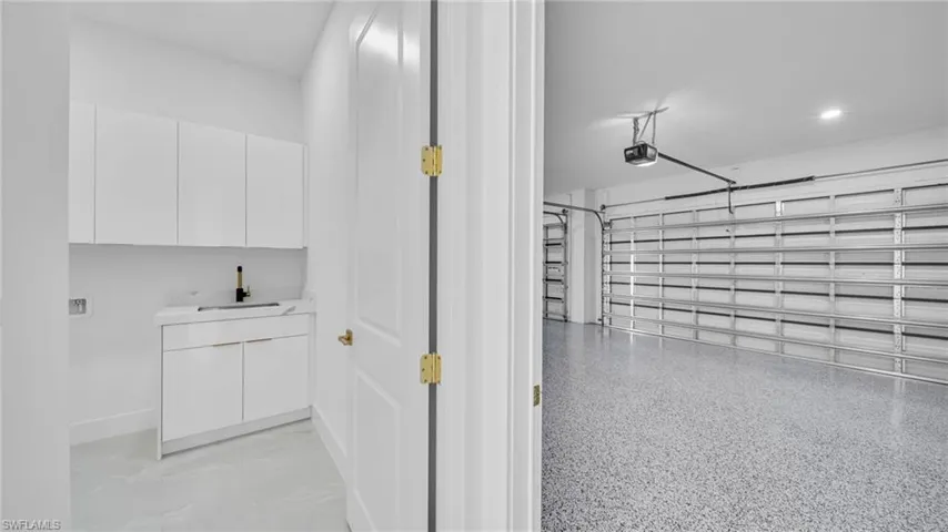 Garage featuring a sink and baseboards