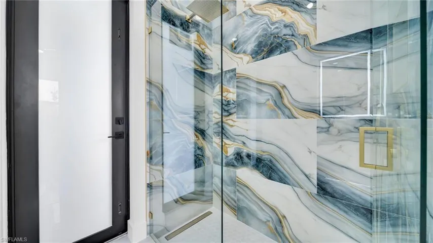 Full bath with a marble finish shower