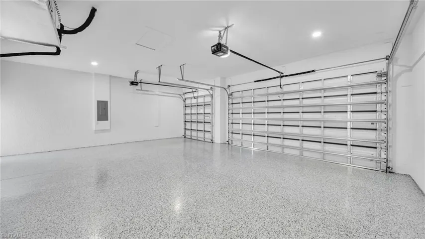 Garage featuring a garage door opener and electric panel