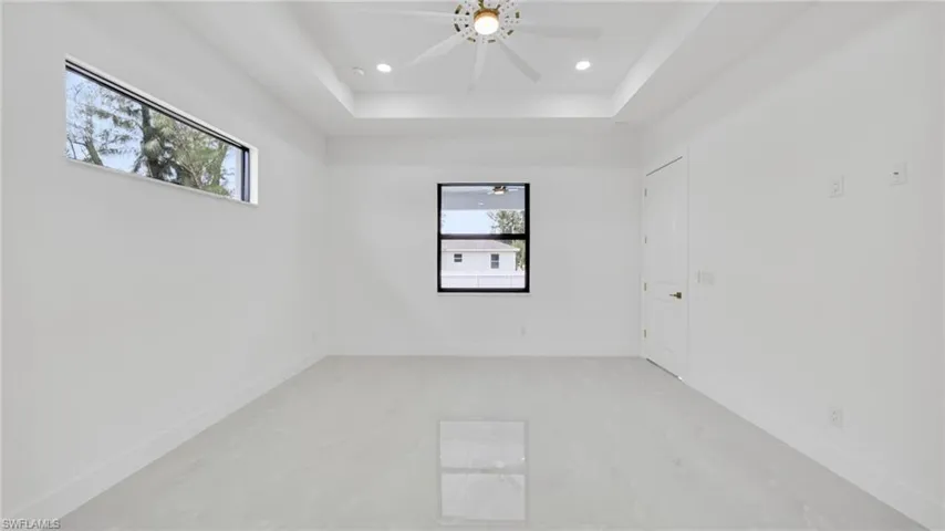 Spare room featuring recessed lighting, a raised ceiling, and a ceiling fan