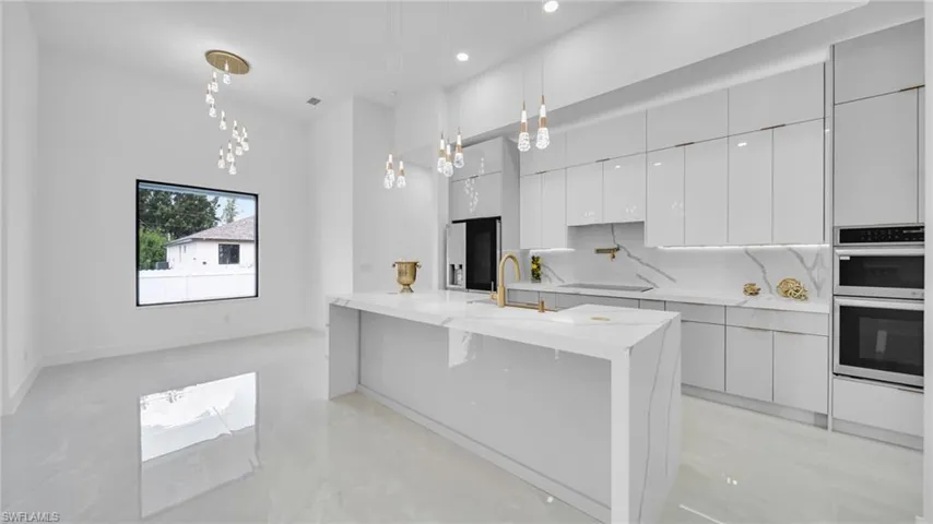 Kitchen with modern cabinets, stainless steel double oven, pendant lighting, decorative backsplash, and recessed lighting