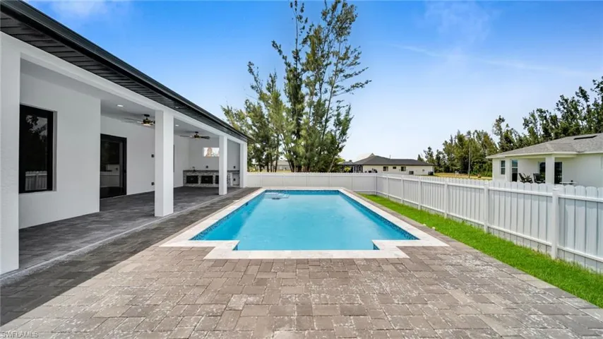 View of pool featuring a patio, a fenced backyard, and a ceiling fan