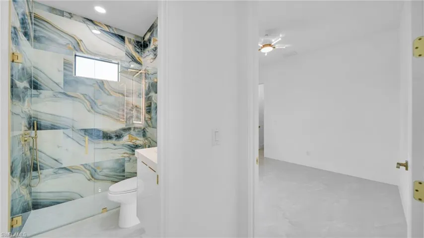 Bathroom with a marble finish shower and vanity