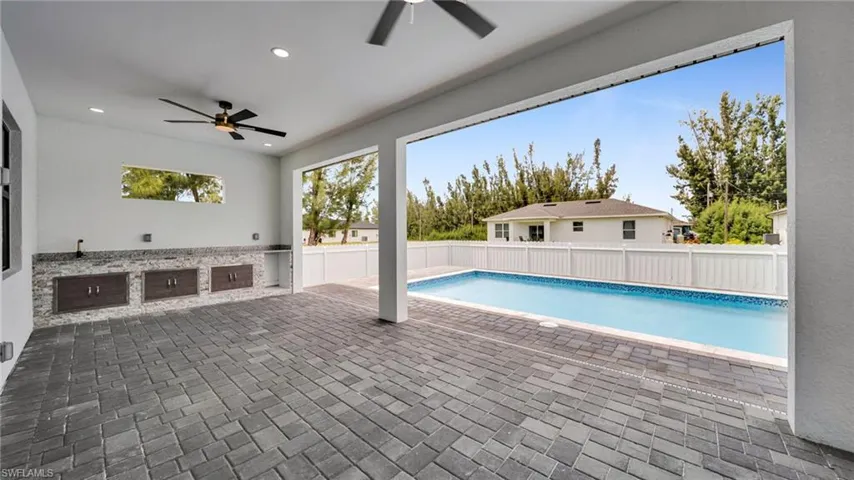 View of swimming pool featuring a patio, a fenced backyard, and a ceiling fan