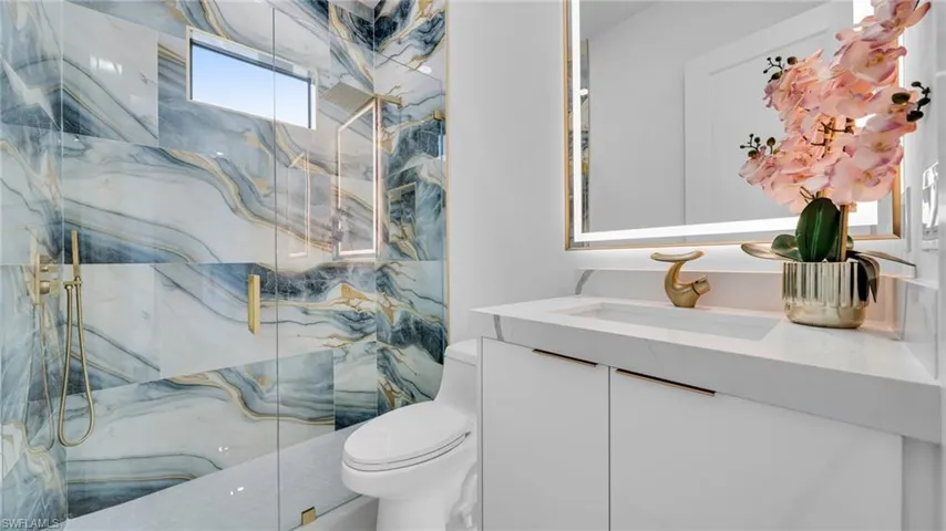 Full bath with a marble finish shower and vanity