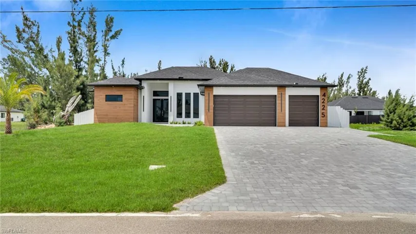 Prairie-style home featuring a garage and decorative driveway