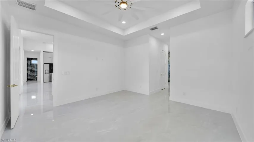 Unfurnished room with recessed lighting, a tray ceiling, and ceiling fan