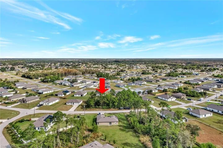 View of property location with nearby suburban area and a tree filled landscape