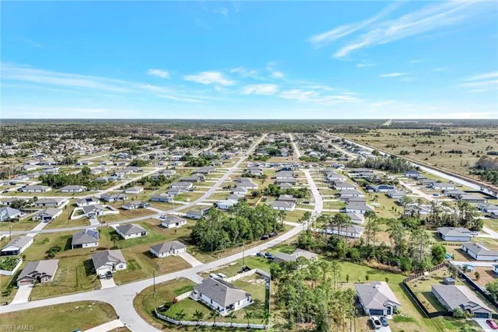 Aerial view of property and surrounding area with nearby suburban area