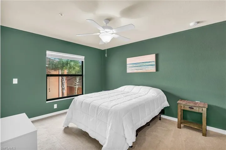 Bedroom with ceiling fan and light colored carpet