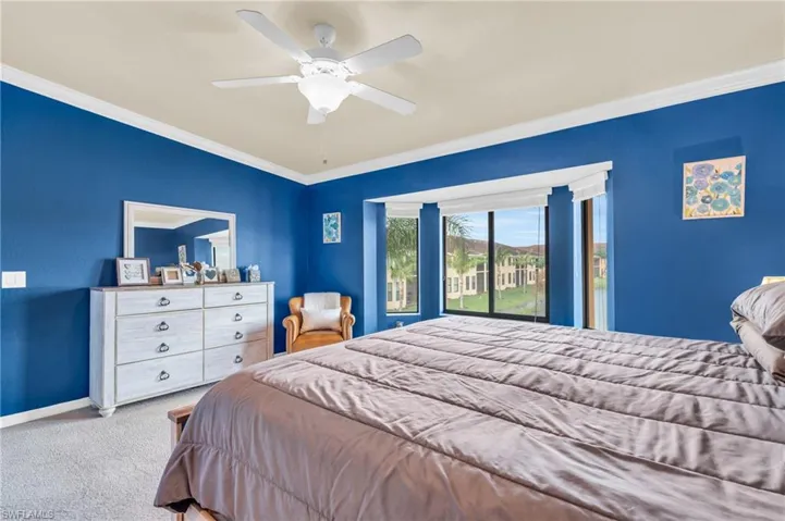 Carpeted bedroom featuring ceiling fan, access to exterior, and ornamental molding