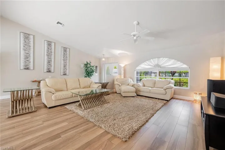 Living room featuring vaulted ceiling and arched window