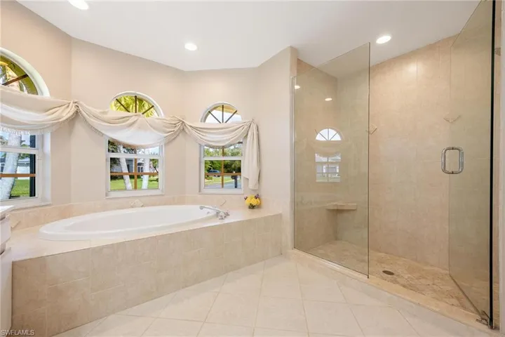 Bathroom featuring Tub, Walk in shower, and a wealth of natural light