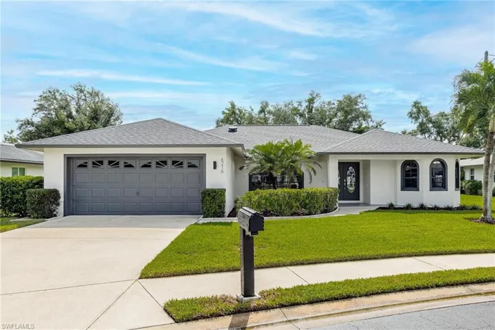 Ranch-style house featuring a front lawn and a garage