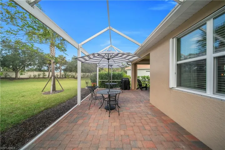 Fenced backyard with a patio area, a lanai, a sunroom, grilling area, and outdoor dining area