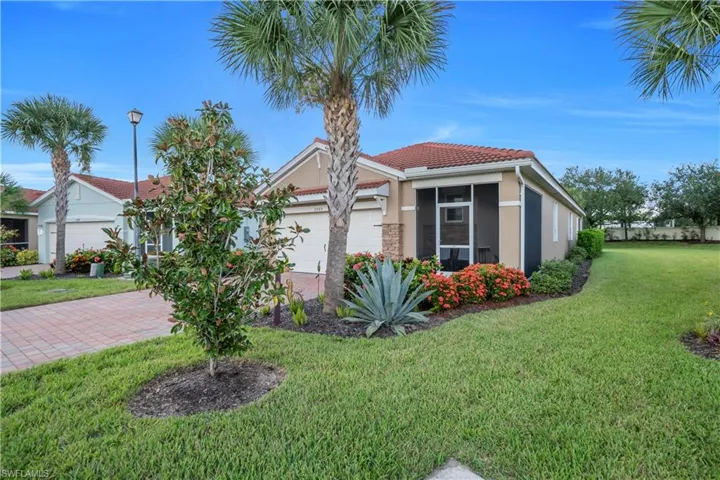 View of front of property featuring stucco siding, a front lawn, a tiled roof, a garage, and decorative driveway