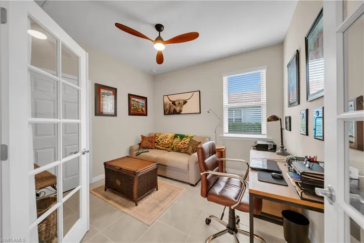 Home office with french doors, light tile patterned floors, and a ceiling fan