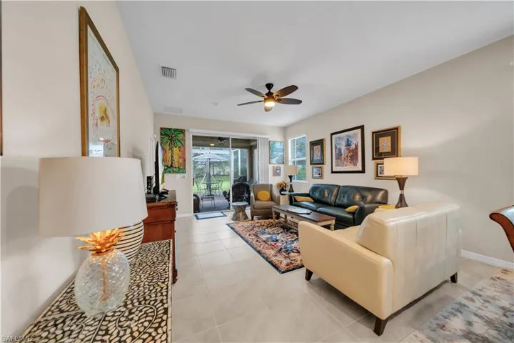 Living area with ceiling fan and light tile patterned floors