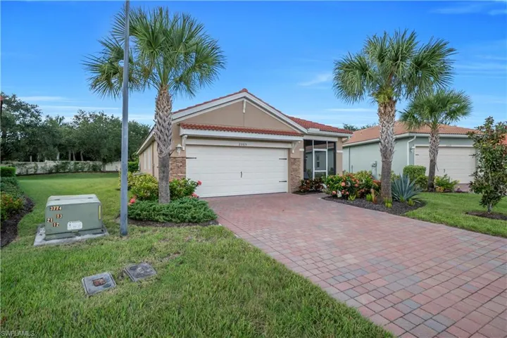 Single story home featuring a front yard, decorative driveway, a tile roof, a garage, and stucco siding